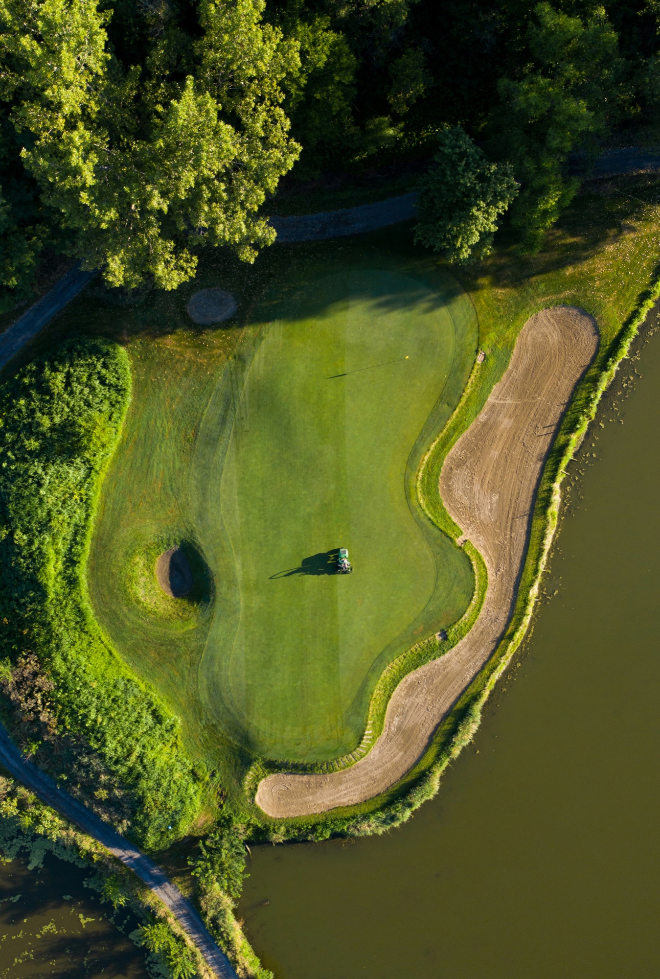 A quiet golf course surrounded by mature trees and open water